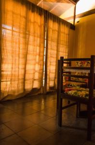 a room with a chair in front of a window at Condomínio Boiçucanga in Boicucanga