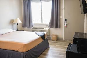 Кровать или кровати в номере Merit Inn and Suites