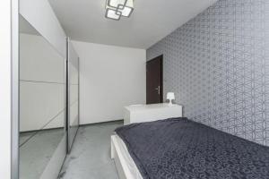 a bedroom with a bed and a black and white tiled wall at Apartament Pruszcz Gdański in Pruszcz Gdański