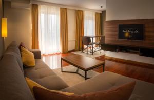 Apartments Feel Belgrade في بلغراد: غرفة معيشة مع أريكة وطاولة