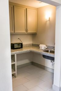 a kitchen counter with a sink and a microwave at Harmony Inn and Suites in Beaumont
