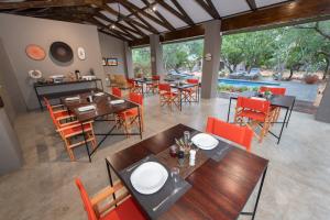 uma sala de jantar com mesas e cadeiras e uma piscina em Nyaleti Lodge em Hoedspruit