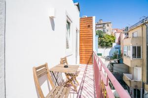 Un balcón con 2 sillas y una mesa de madera. en Liberdade Apartment, en Lisboa