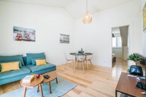 a living room with a blue couch and a table at Liberdade Apartment in Lisbon