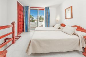 a bedroom with two beds and a balcony at Parque Santiago IV in Playa de las Americas