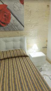 1 dormitorio con 1 cama y 1 mesa con lámpara en Borgo dei Filitti en Palmariggi