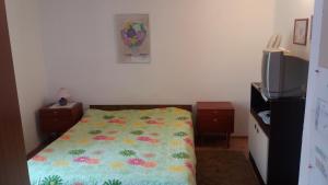 een slaapkamer met een bed met een bloemendeken erop bij Studio apartman in Dramalj