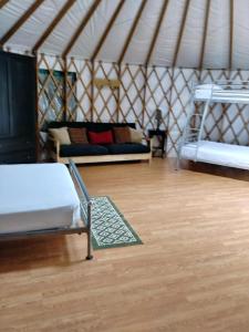 a room with a bed and a couch in a yurt at Pine Mountain RV Resort in Pine Mountain