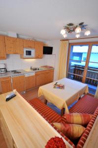 a kitchen with a table and a couch in a room at Hotel-Pension Faneskla in Silbertal