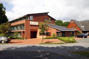 弗里索伊特兰德豪斯普美耶酒店的前面有停车位的砖砌建筑