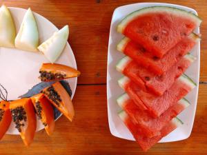 a plate of watermelon and other fruits on a table at Pousada Mandala in Bonito