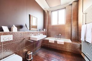 a bathroom with a tub and a sink and a mirror at B&B X2Brussels in Brussels