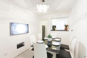 Holiday Home Revelin- Great Location في دوبروفنيك: غرفة طعام مع طاولة سوداء وكراسي بيضاء
