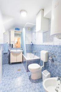 een blauw betegelde badkamer met een toilet en een wastafel bij Holiday Home Revelin- Great Location in Dubrovnik