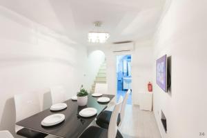 Holiday Home Revelin- Great Location في دوبروفنيك: غرفة طعام مع طاولة سوداء وكراسي بيضاء