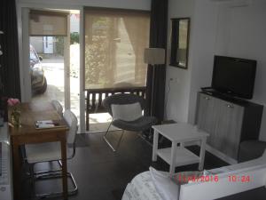 弗萊門的住宿－Magnolia appartement，客厅配有电视和桌椅