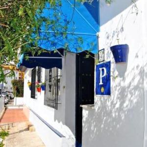 una señal azul de estacionamiento en el lateral de un edificio en Hostal Puerto de Santa Maria, en El Puerto de Santa María