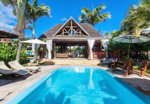 a villa with a swimming pool and a house at Hotel Aconchego Porto de Galinhas in Porto De Galinhas