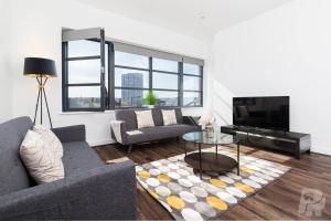 a living room with a couch and a table at Birmingham City Penthouse Jewellery Quarter in Birmingham