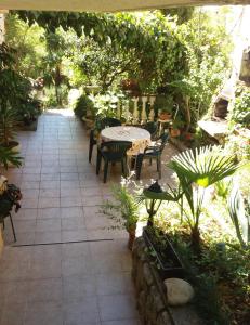 een patio met een tafel, stoelen en planten bij Studio apartman in Dramalj