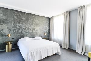 a bedroom with a white bed and a gray wall at B&B X2Brussels in Brussels