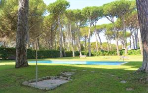a swimming pool in the middle of a park with trees at porta del golf in Pals