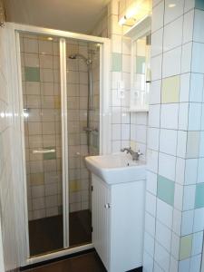 a white bathroom with a sink and a shower at Appartement AanZee in Hoek van Holland