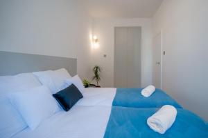 a white bed with blue and white pillows on it at Skwer Kościuszki in Gdynia