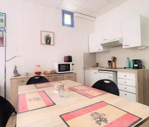 カンヌにあるClémenceau Plagesのテーブルと椅子2脚、白いキャビネット付きのキッチンが備わります。