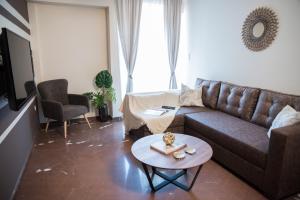 a living room with a couch and a table at AT.thea ATHENS BOUTIQUE APARTMENTS in Athens