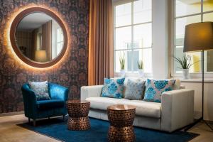 a living room with a white couch and a mirror at Hotel Post Wrann in Velden am Wörthersee