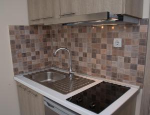 a kitchen counter with a sink and a stove at Olympic Coast in Olympic Beach +37 photos
