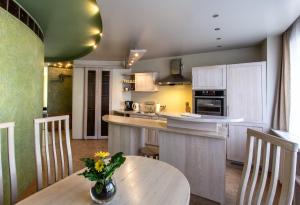 a kitchen with a table with a vase of flowers on it at Gerda Apartments in Druskininkai