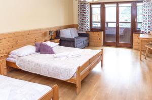 Un dormitorio con 2 camas y una silla. en Pensjonat Jastrzębia Turnia en Zakopane