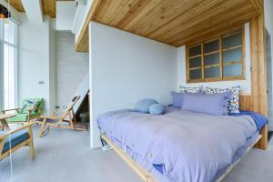 a bed in a room with a wooden ceiling at Admiring Island in Anping