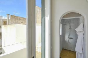 a bathroom with a shower and a window at Pascaraymondo Suite Palace in Gallipoli