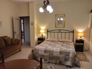 a bedroom with a bed and a couch and a table at B&B Tio Pepe in Roseto degli Abruzzi