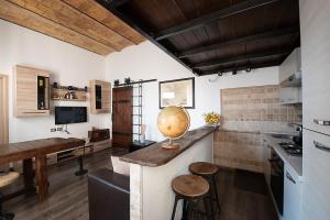 cocina con encimera con taburetes y mesa en Home House Borgo Pio 195, en Roma