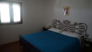 una camera da letto con un letto con lenzuola blu e una finestra di Villa Anna a SantʼAndrea