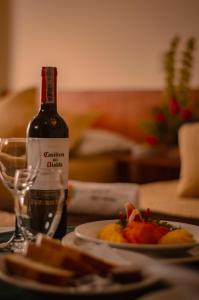 a bottle of wine sitting next to a plate of food at Hotel San Ignacio Plaza in Tunja