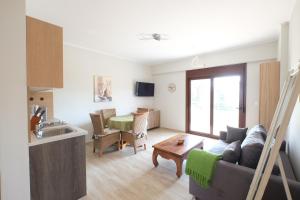 Una cocina y una sala de estar con un sofá y una mesa. en Villa Valerie, en Nikiti