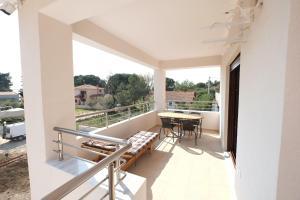 Un balcón de una casa con una mesa y sillas. en Villa Valerie, en Nikiti