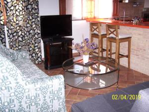 a living room with a tv and a glass table at Casa Rural Altozano Elche de la Sierra in Elche de la Sierra