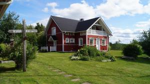 a red house with a street sign in front of it at Holiday Village Kuukiuru in Vuostimo