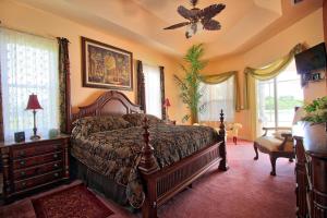 a bedroom with a bed and a ceiling fan at Villa Princess in Cape Coral +19 photos