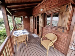 eine Hütte mit einem Tisch und Stühlen auf einer Terrasse in der Unterkunft karureve in Deshaies