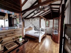 a bedroom with a white bed in a room with wooden floors at karureve in Deshaies