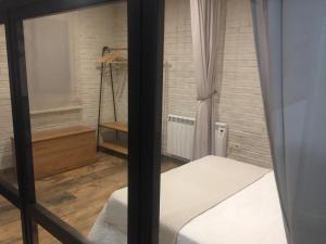 Habitación pequeña con cama y ducha en Ático del Rojas en Toledo