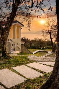 a building with the sun setting in the background at Maison Balù Villa in Torri del Benaco