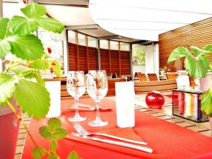 ヴィレ・ル・ラックにあるLogis Hotel le Franceの赤いテーブルクロスにワイングラスをかけたテーブル